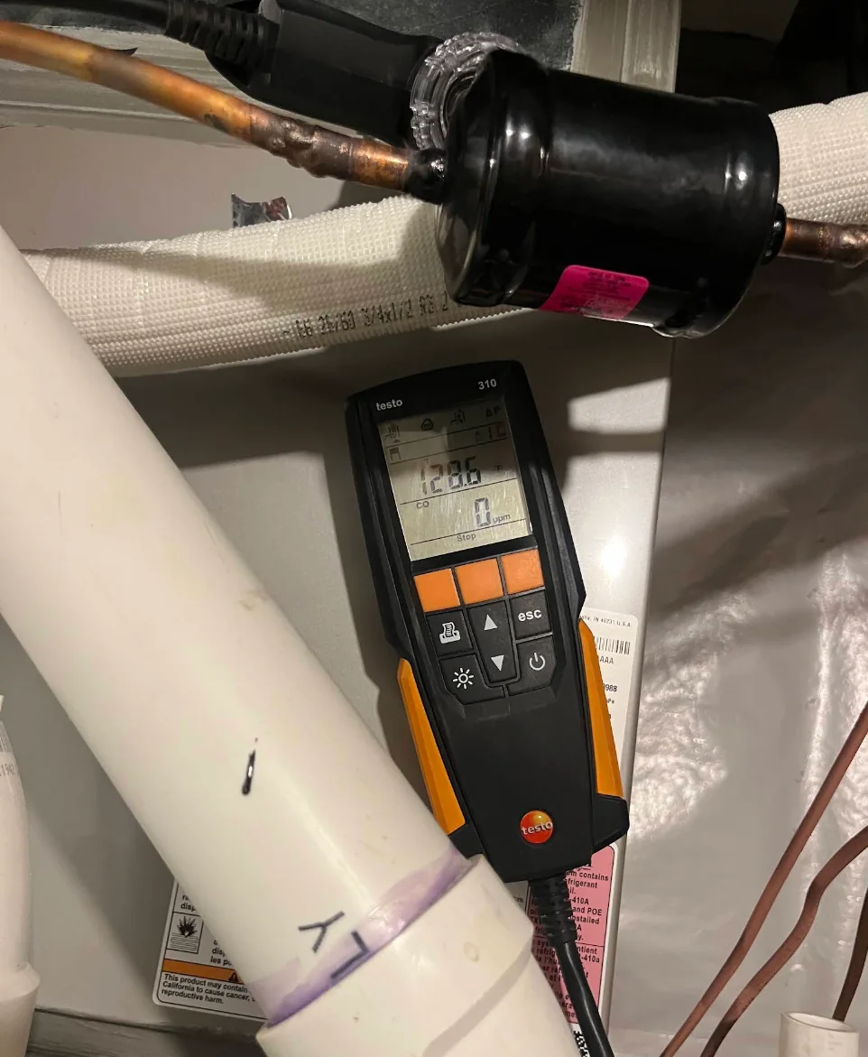 Combustion testing instrument positioned at HVAC equipment
