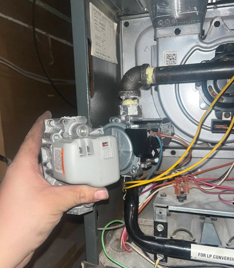 Gas-control component being serviced beside an open furnace