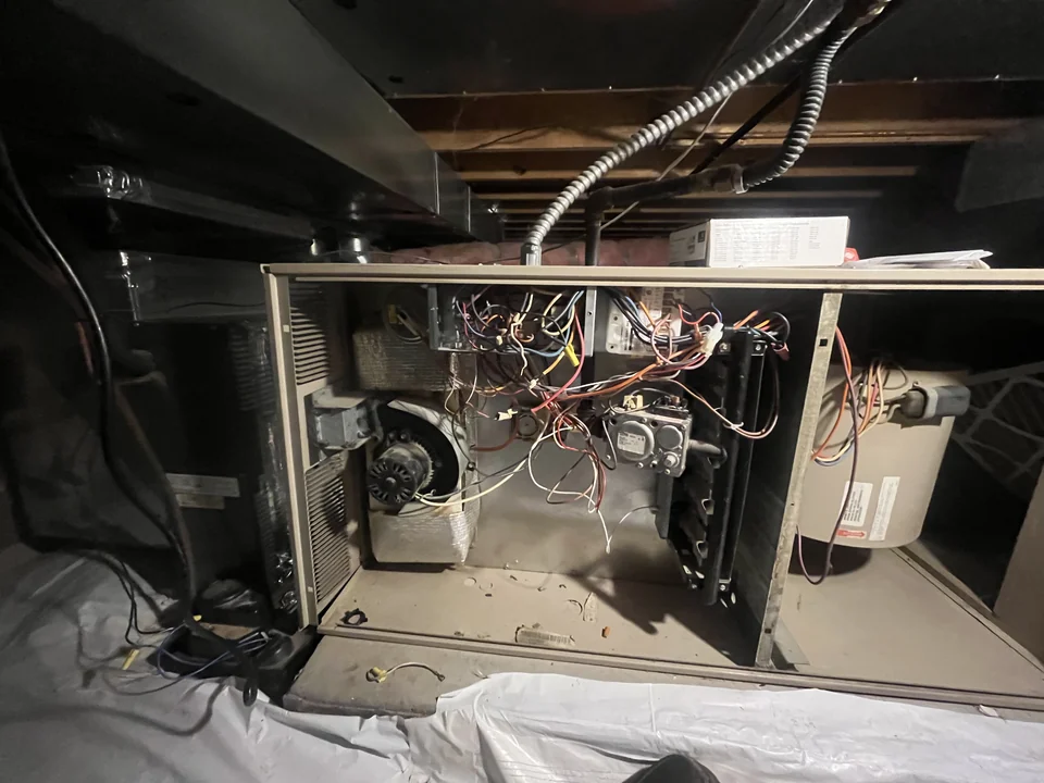 The existing furnace in a crawlspace before replacement